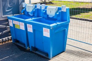 portable hand wash station next to a fence